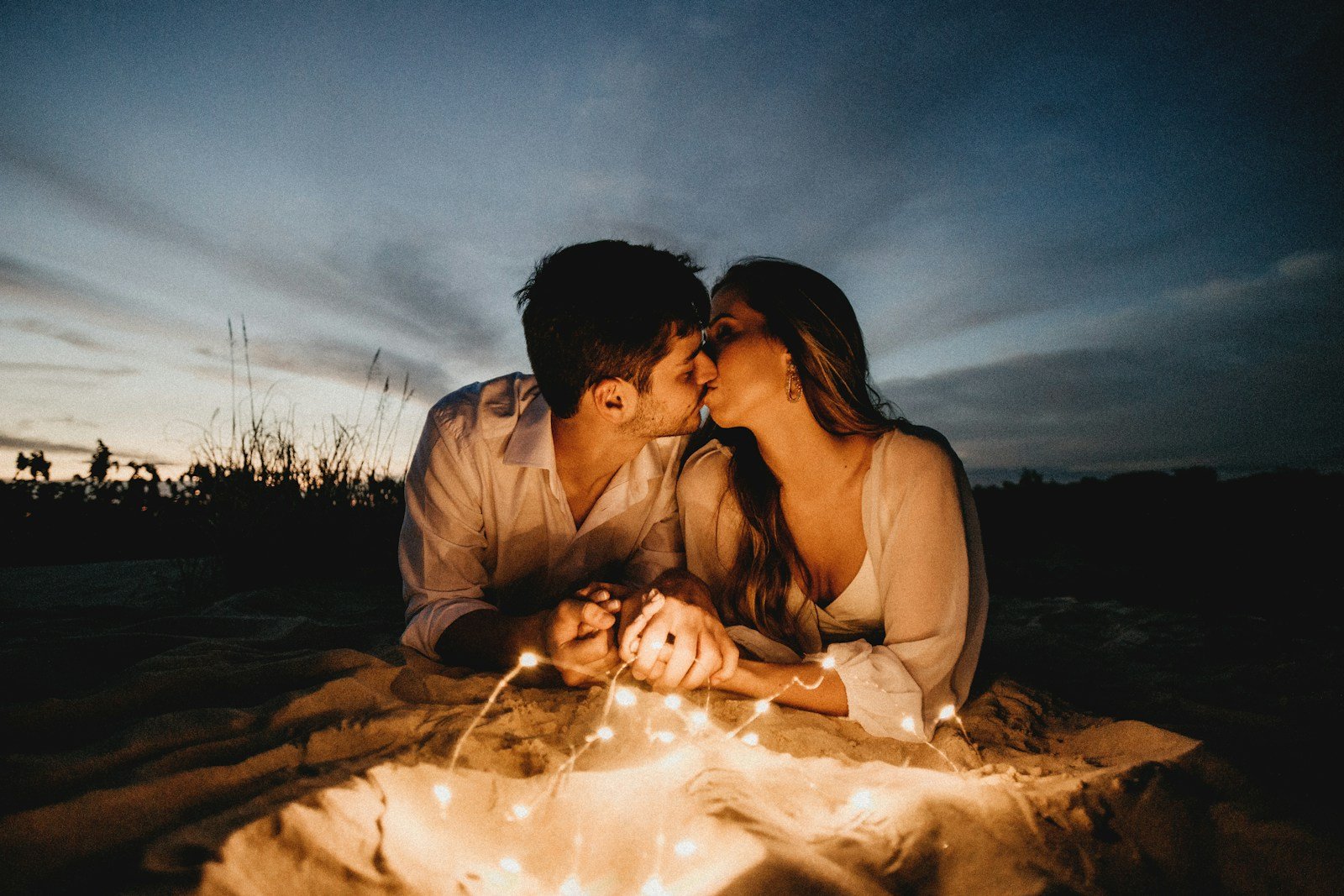 Regalos de San Valentín en Colombia, man and woman kissing on brown sand during night time